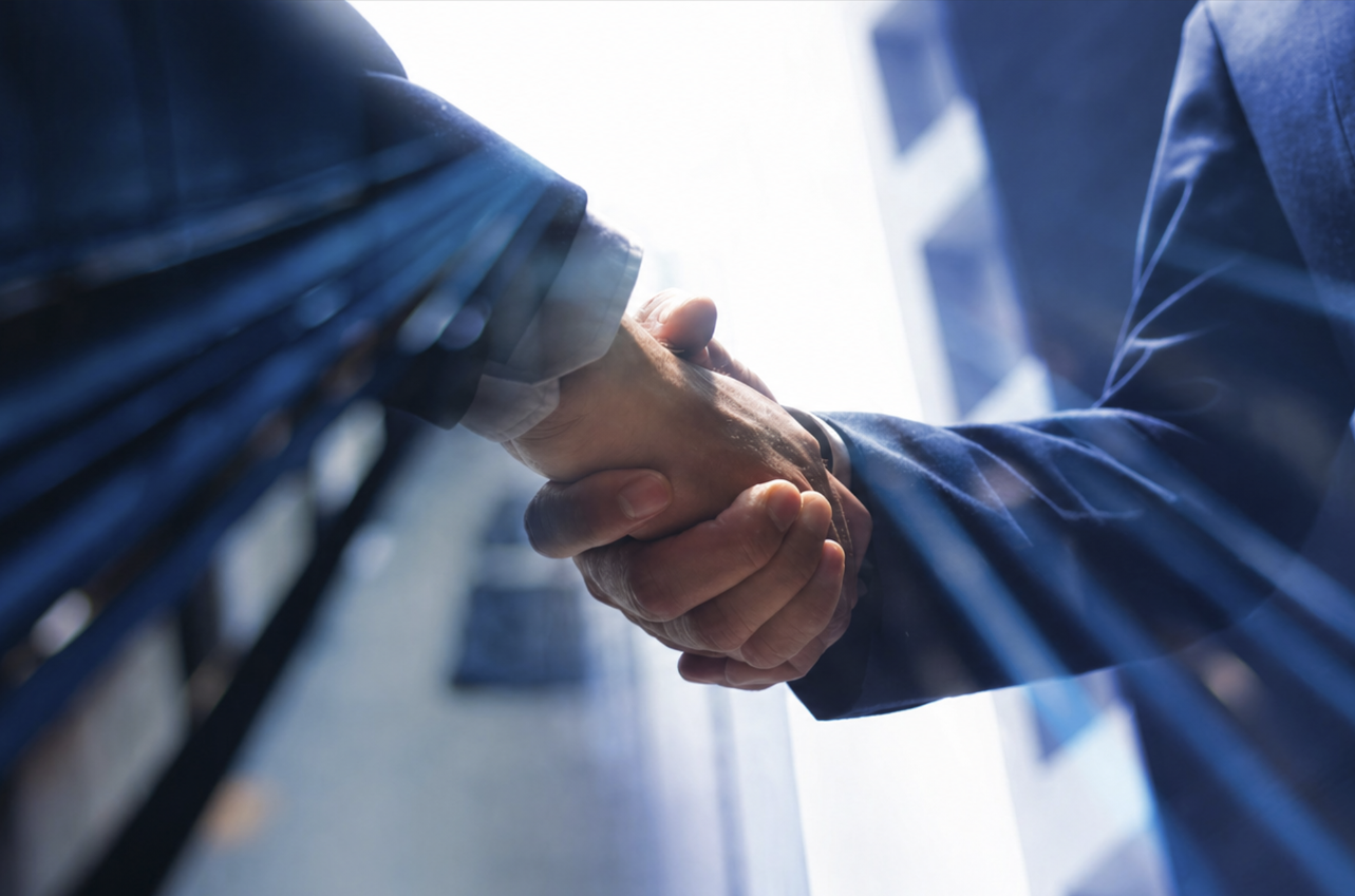 Business professionals shaking hands outside an office